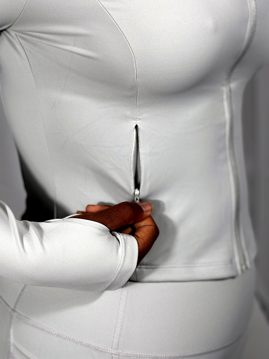 Hidden zip side pocket and thumbhole cuff on The Standard Jacket in Pearl Grey